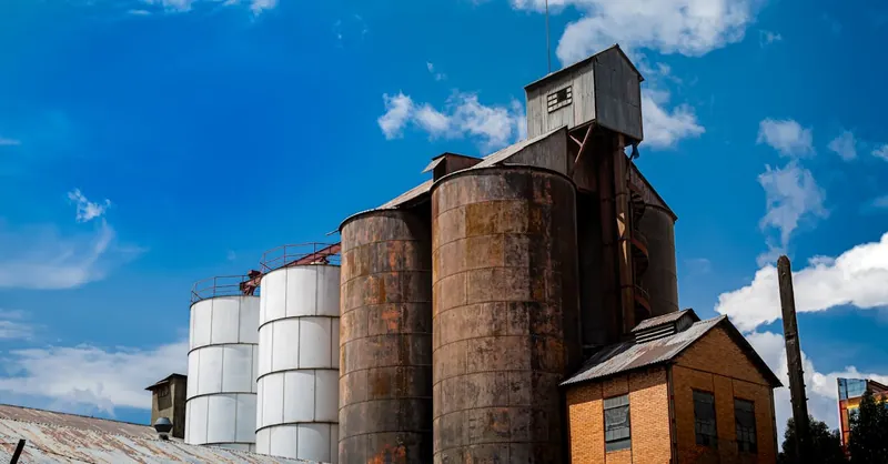 Aged industrial silos with rusty texture under bright blue skies in La Paz, Bolivia.