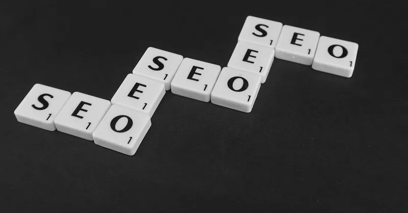 SEO spelled with Scrabble tiles on a black surface, representing search engine optimization concepts.